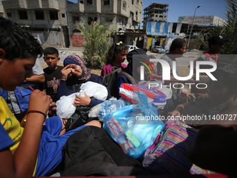 Displaced Palestinians, who are fleeing north Gaza after being ordered by the Israeli army to move southward amid the Israel-Hamas conflict,...