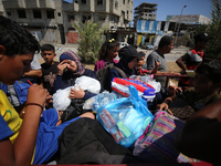 Displaced Palestinians, who are fleeing north Gaza after being ordered by the Israeli army to move southward amid the Israel-Hamas conflict,...