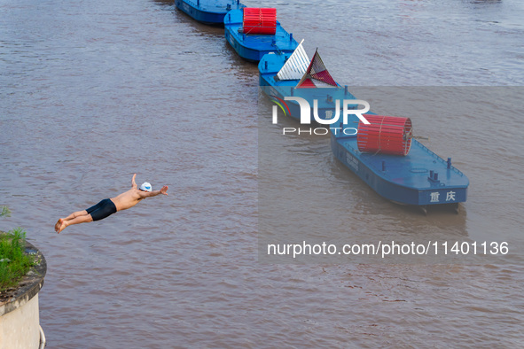 A citizen is jumping into the Yangtze River for a swim after the water level rose sharply in Chongqing, China, on July 11, 2024. It is repor...