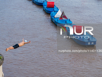 A citizen is jumping into the Yangtze River for a swim after the water level rose sharply in Chongqing, China, on July 11, 2024. It is repor...