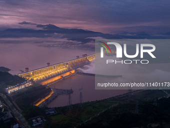 The Three Gorges Dam is opening three holes to release flood water at sunset in Yichang, Hubei province, China, on July 11, 2024. (