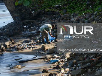 A scavenger is collecting plastic bottle waste at Padang Beach in Padang City, West Sumatra, Indonesia, on July 11, 2024. The lack of awaren...