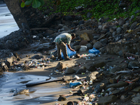 A scavenger is collecting plastic bottle waste at Padang Beach in Padang City, West Sumatra, Indonesia, on July 11, 2024. The lack of awaren...