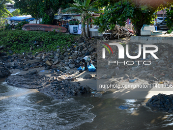 A scavenger is collecting plastic bottle waste at Padang Beach in Padang City, West Sumatra, Indonesia, on July 11, 2024. The lack of awaren...