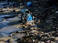 A scavenger is collecting plastic bottle waste at Padang Beach in Padang City, West Sumatra, Indonesia, on July 11, 2024. The lack of awaren...