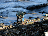 A scavenger is collecting plastic bottle waste at Padang Beach in Padang City, West Sumatra, Indonesia, on July 11, 2024. The lack of awaren...