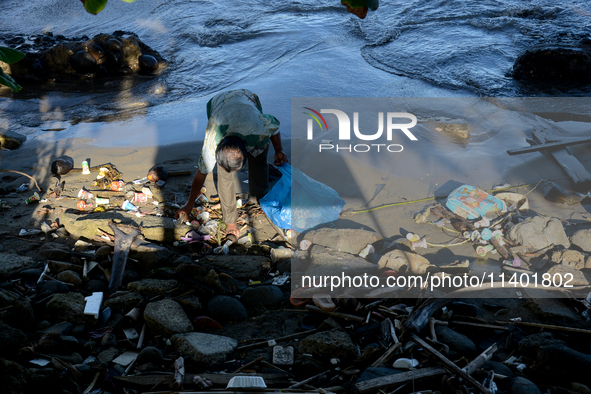 A scavenger is collecting plastic bottle waste at Padang Beach in Padang City, West Sumatra, Indonesia, on July 11, 2024. The lack of awaren...