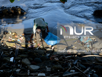 A scavenger is collecting plastic bottle waste at Padang Beach in Padang City, West Sumatra, Indonesia, on July 11, 2024. The lack of awaren...