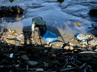 A scavenger is collecting plastic bottle waste at Padang Beach in Padang City, West Sumatra, Indonesia, on July 11, 2024. The lack of awaren...