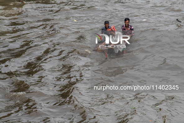 People are wading through a waterlogged street after heavy rain in Dhaka, Bangladesh, on July 12, 2024. 