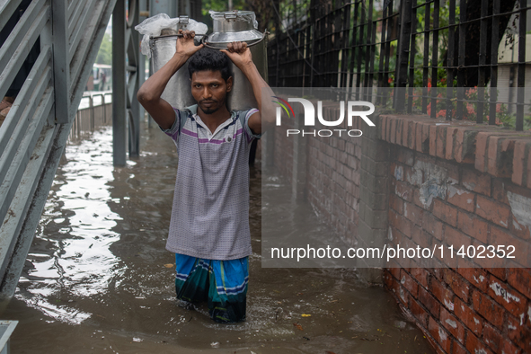 People are wading through a waterlogged street after heavy rain in Dhaka, Bangladesh, on July 12, 2024. 