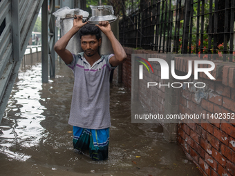 People are wading through a waterlogged street after heavy rain in Dhaka, Bangladesh, on July 12, 2024. (