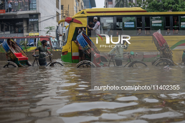 Vehicles are getting stuck on a waterlogged street after heavy rain in Dhaka, Bangladesh, on July 12, 2024. 