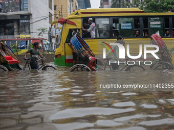 Vehicles are getting stuck on a waterlogged street after heavy rain in Dhaka, Bangladesh, on July 12, 2024. (