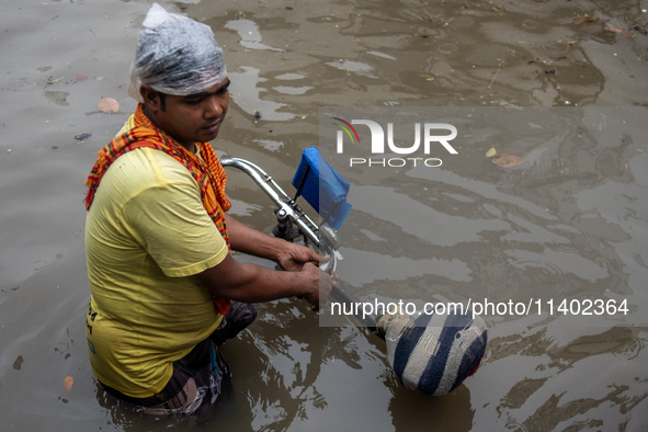 A rickshaw puller is waiting for passengers on a waterlogged street after heavy rain in Dhaka, Bangladesh, on July 12, 2024. 