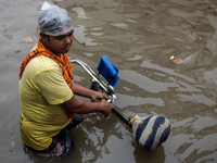 A rickshaw puller is waiting for passengers on a waterlogged street after heavy rain in Dhaka, Bangladesh, on July 12, 2024. (