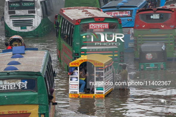 Vehicles are getting stuck on a waterlogged street after heavy rain in Dhaka, Bangladesh, on July 12, 2024. 