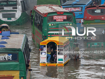 Vehicles are getting stuck on a waterlogged street after heavy rain in Dhaka, Bangladesh, on July 12, 2024. (