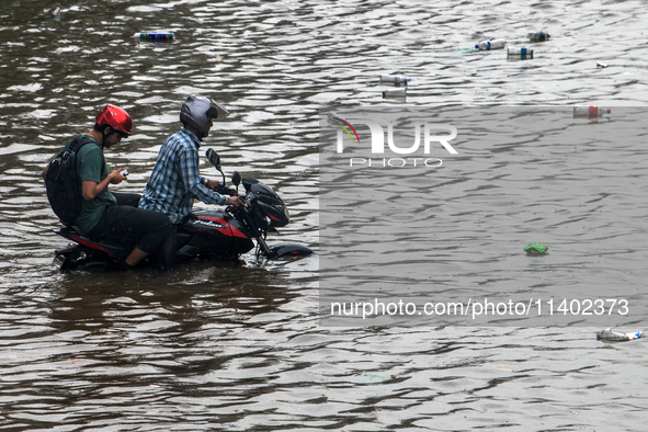 A vehicle is running through a waterlogged street after heavy rain in Dhaka, Bangladesh, on July 12, 2024. 