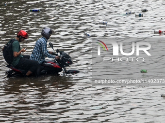 A vehicle is running through a waterlogged street after heavy rain in Dhaka, Bangladesh, on July 12, 2024. (