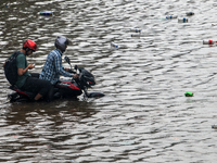 A vehicle is running through a waterlogged street after heavy rain in Dhaka, Bangladesh, on July 12, 2024. (