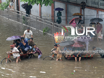 Passengers are riding in vans to go through a waterlogged street after heavy rain in Dhaka, Bangladesh, on Friday, July 12, 2024. (