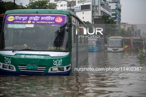 Vehicles are getting stuck on a waterlogged street after heavy rain in Dhaka, Bangladesh, on July 12, 2024. 