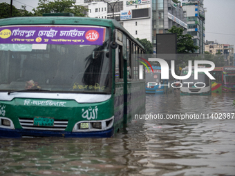 Vehicles are getting stuck on a waterlogged street after heavy rain in Dhaka, Bangladesh, on July 12, 2024. (