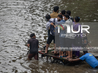 Passengers are riding in vans to go through a waterlogged street after heavy rain in Dhaka, Bangladesh, on Friday, July 12, 2024. (