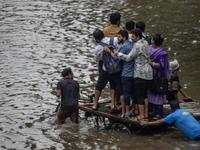 Passengers are riding in vans to go through a waterlogged street after heavy rain in Dhaka, Bangladesh, on Friday, July 12, 2024. (