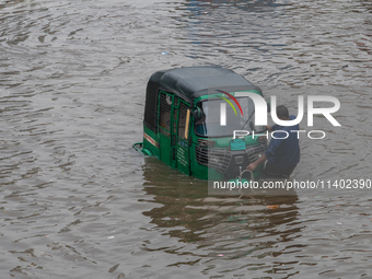 Vehicles are getting stuck on a waterlogged street after heavy rain in Dhaka, Bangladesh, on July 12, 2024. (