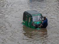 Vehicles are getting stuck on a waterlogged street after heavy rain in Dhaka, Bangladesh, on July 12, 2024. (