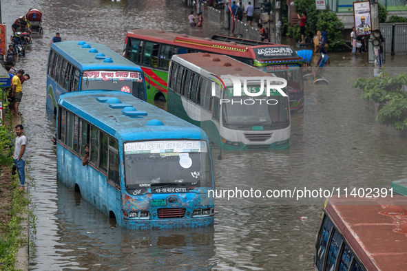 Vehicles are getting stuck on a waterlogged street after heavy rain in Dhaka, Bangladesh, on July 12, 2024. 