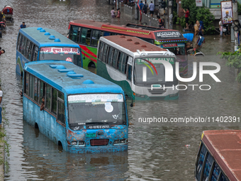 Vehicles are getting stuck on a waterlogged street after heavy rain in Dhaka, Bangladesh, on July 12, 2024. (