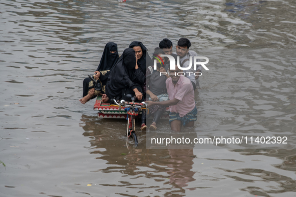 Passengers are riding in vans to go through a waterlogged street after heavy rain in Dhaka, Bangladesh, on Friday, July 12, 2024. 