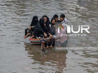 Passengers are riding in vans to go through a waterlogged street after heavy rain in Dhaka, Bangladesh, on Friday, July 12, 2024. (