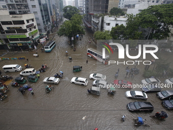 People are going through a flooded street after heavy monsoon rainfall in Dhaka, Bangladesh, on July 12, 2024. (