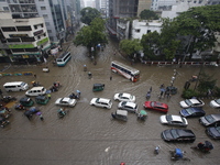 People are going through a flooded street after heavy monsoon rainfall in Dhaka, Bangladesh, on July 12, 2024. (