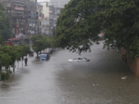 People are going through a flooded street after heavy monsoon rainfall in Dhaka, Bangladesh, on July 12, 2024. (