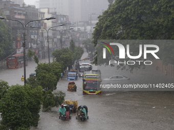 People are going through a flooded street after heavy monsoon rainfall in Dhaka, Bangladesh, on July 12, 2024. (