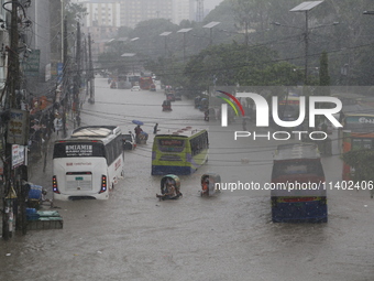 People are going through a flooded street after heavy monsoon rainfall in Dhaka, Bangladesh, on July 12, 2024. (