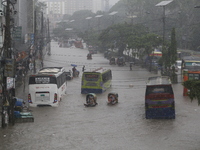 People are going through a flooded street after heavy monsoon rainfall in Dhaka, Bangladesh, on July 12, 2024. (