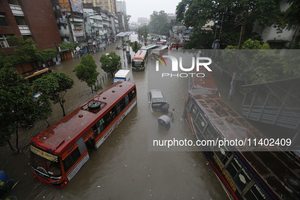 People are going through a flooded street after heavy monsoon rainfall in Dhaka, Bangladesh, on July 12, 2024. 