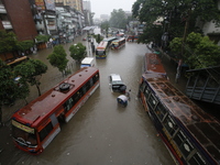 People are going through a flooded street after heavy monsoon rainfall in Dhaka, Bangladesh, on July 12, 2024. (