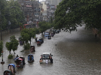 People are going through a flooded street after heavy monsoon rainfall in Dhaka, Bangladesh, on July 12, 2024. (