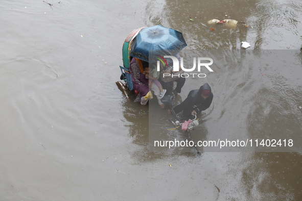 A rickshaw puller is going through a flooded street after heavy monsoon rainfall in Dhaka, Bangladesh, on July 12, 2024. 