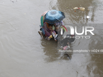 A rickshaw puller is going through a flooded street after heavy monsoon rainfall in Dhaka, Bangladesh, on July 12, 2024. (