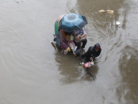 A rickshaw puller is going through a flooded street after heavy monsoon rainfall in Dhaka, Bangladesh, on July 12, 2024. (