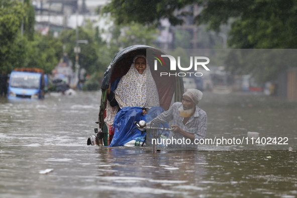 A rickshaw puller is going through a flooded street after heavy monsoon rainfall in Dhaka, Bangladesh, on July 12, 2024. 