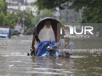 A rickshaw puller is going through a flooded street after heavy monsoon rainfall in Dhaka, Bangladesh, on July 12, 2024. (